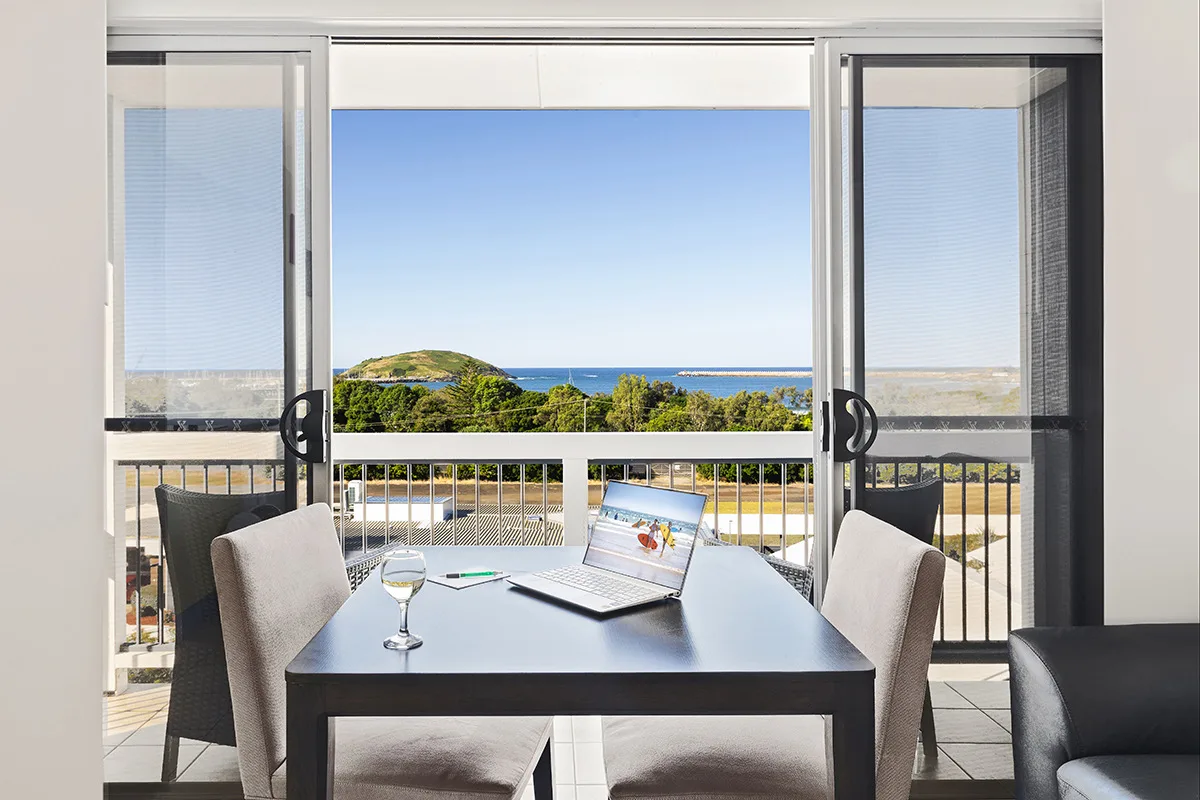 An owner's laptop set up with an ocean view at The Observatory, one of the independent properties Indi runs commercial services for